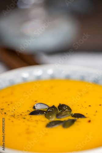 Kürbissuppe in einer Suppenschale auf einem gedeckten Tisch. Nahaufnahmeder Suppe.