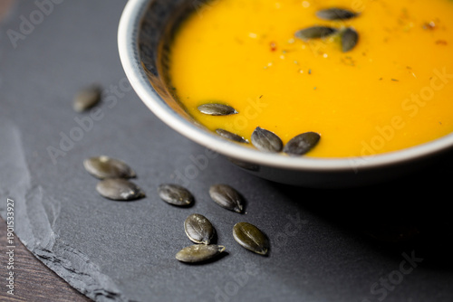 Kürbissuppe in einer Suppenschale auf einem gedeckten Tisch. Nahaufnahmeder Suppe.
