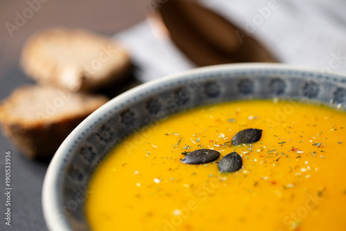 Kürbissuppe in einer Suppenschale auf einem gedeckten Tisch. Nahaufnahmeder Suppe.