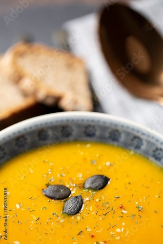 Kürbissuppe in einer Suppenschale auf einem gedeckten Tisch. Nahaufnahmeder Suppe.