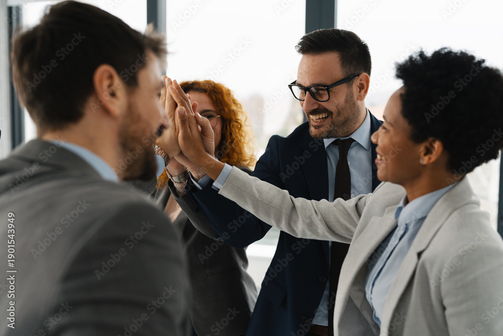 © Novak - A diverse team of successful business professionals celebrating a victory in a modern office. They are cheering, raising their hands, and making triumphant gestures after closing a deal © Novak - A diverse team of successful business professionals celebrating a victory in a modern office. They are cheering, raising their hands, and making triumphant gestures after closing a deal