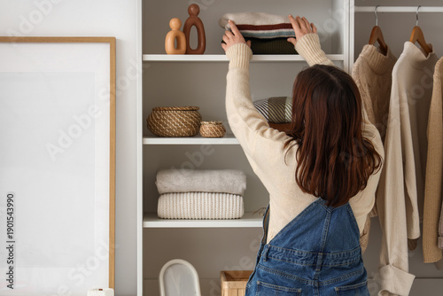 Woman putting folded sweate...