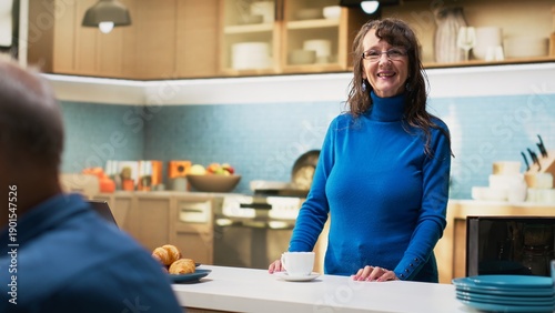 Photos Senior wife standing in bright kitchen at home enjoying coffee cup and peaceful relaxation