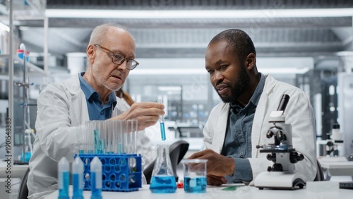 Foto Teamworking lab researchers evaluating blue compound solution for new drug formulation
