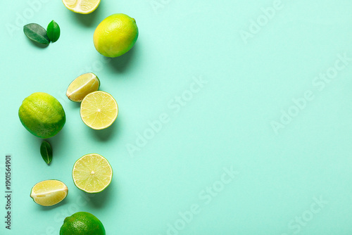 Tableau sur toile Fresh ripe limes and leaves on turquoise background