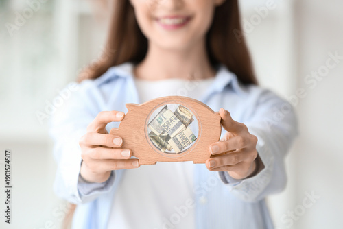 Young woman with piggy bank...
