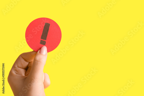 Woman holding paper exclama...