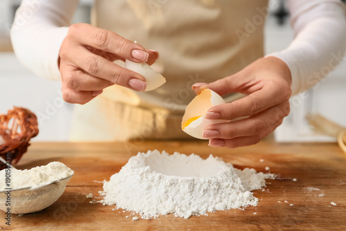 Woman cracking egg into flo...