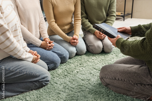 Group of people praying wit...