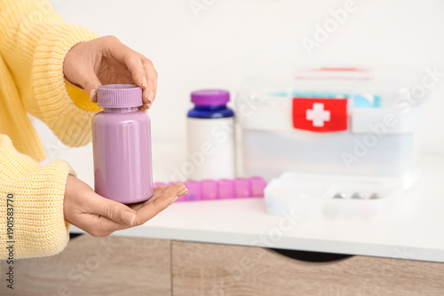 Woman holding pill box agai...