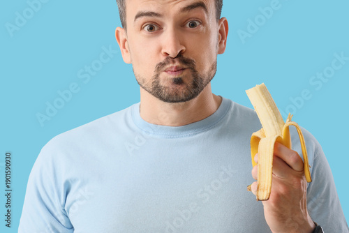 Young man eating banana on ...