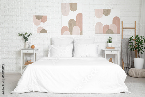 Cuadro en lienzo Interior of beautiful bedroom with comfy bed, bedside tables and pictures on whi