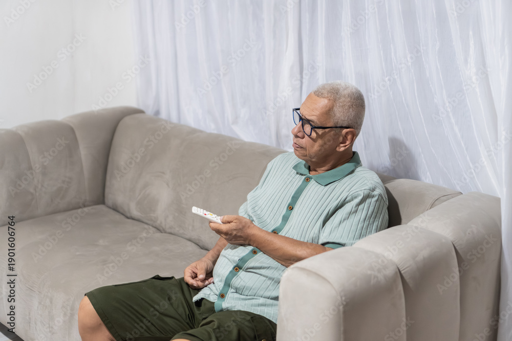 Fototapeta premium Routines senior man relaxing at home watching tv