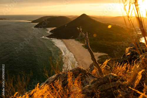 Fotografía Sandy beach and ocean shoreline at sunset in Zenith Beach, Port Stephens, New South Wales, Australia, with soft evening light, coastal vegetation, and calm sea
