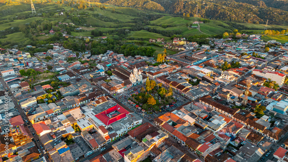 Fototapeta premium A vibrant aerial view of Filandia showcasing colorful rooftops, greenery in the background, and a church in the town center.