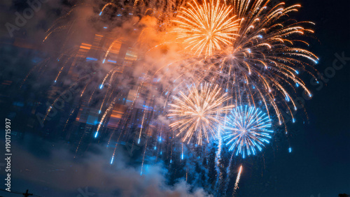 Spectacular orange and blue fireworks blooming in night sky