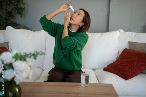 Foto Woman applying eye drops for eye care and vision health