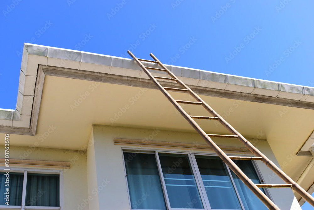 Fototapeta premium wood ladder for repair house's gutter before rainy season