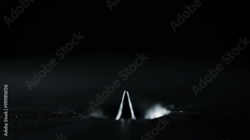 A captivating close-up of a liquid spike rising and falling, showcasing intricate fluid dynamics and ripples.