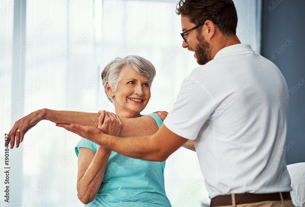 Fototapeta premium Smile, old woman and stretching with physiotherapy at house for mobility, muscle exercise and recovery. Man, help and elderly person for physical therapy, injury assessment and medical rehabilitation