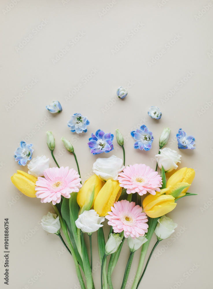 Fototapeta premium Fresh bouquet of beautiful spring flowers top view. Greeting card for International Women Day or Mother day background. Flat lay.