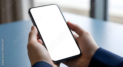 Close Up View of Hands Holding Blank Smartphone Screen with Blue Table and Blurred Background