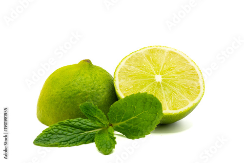 Foto One whole lime and one half-cut lime with fragrant mint leaves on white
