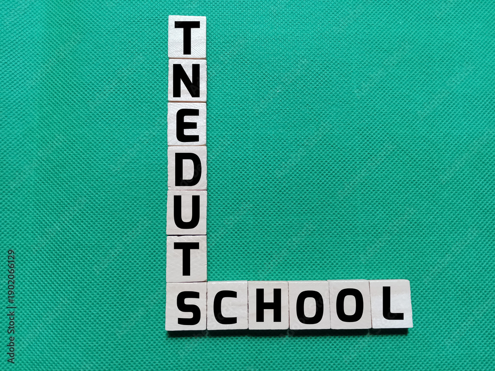 Obraz premium Alphabet letters with the words SCHOOL and STUDENT in a crossword puzzle on a green background. Photo concept about education.