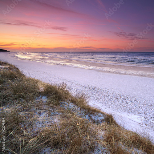A wide view over the wintry Baltic Sea beach with its frozen coastline.