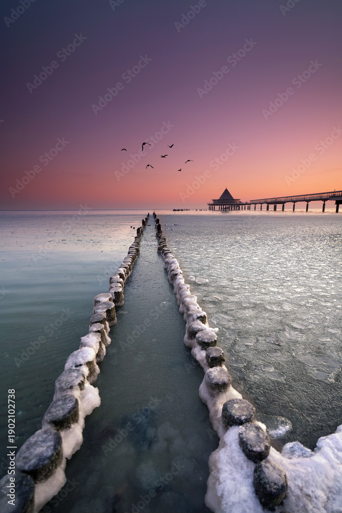 Fototapeta premium old wooden jetty on the beach at the pier in Heringsdorf, Usedom, in winter