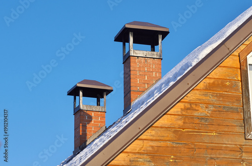 A chimney pipe on the cap. A winter house roof