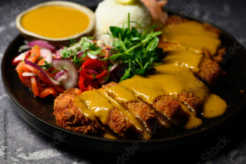 Chicken katsu curry with rice on rustic table