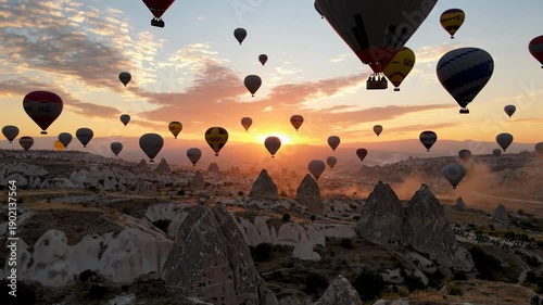 Hot air balloons ascend over unique landscape at sunrise or sunset