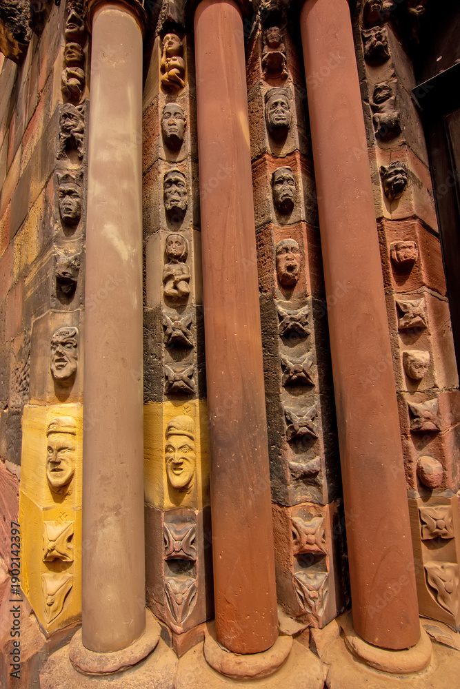 Fototapeta premium Close view of carved Gothic church pillar showing medieval faces and stone ornament.