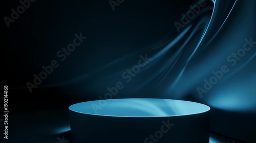 A dark, minimalist image features a lit cylindrical platform against a flowing blue backdrop. Lighting creates a subtle contrast