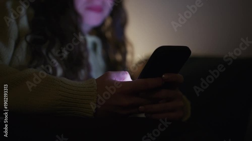 close up of a person scrolling on a smartphone in a dark room, with screen glow illuminating hands and face, representing late night screen time digital habits and modern technology lifestyle concepts