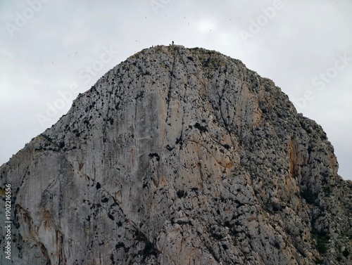 Obraz na płótnie Rugged peak under cloudy sky, Silent elevated mountain with shadowed ledges and