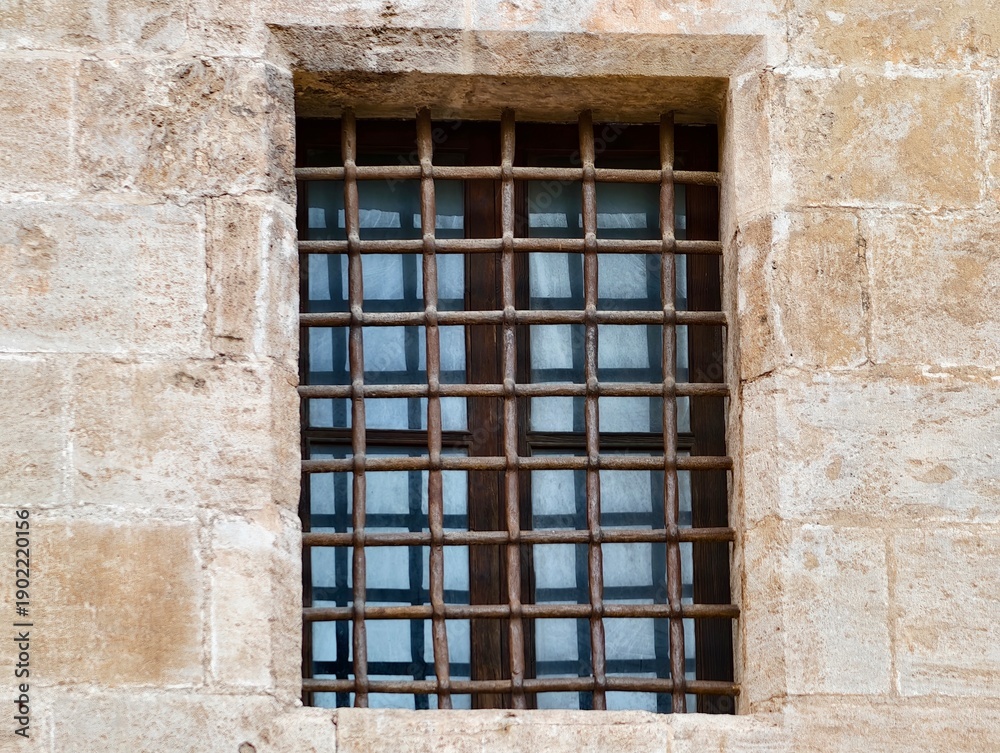 Obraz premium Industrial style window with reflections, Stoneframed window featuring reflective glass and iron bars