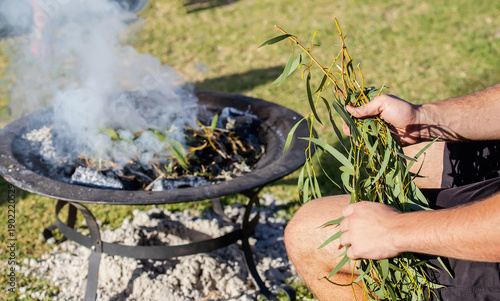 Human hands with green branches, smoking ritual dish, Australian aboriginal smoking ceremony, ritual rite at an indigenous community event