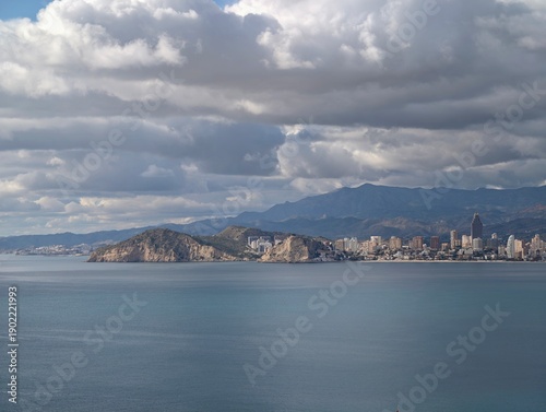 Obraz na plátně Dramatic atmospheric imagery with soaring clouds over coastal cityscape and vibr
