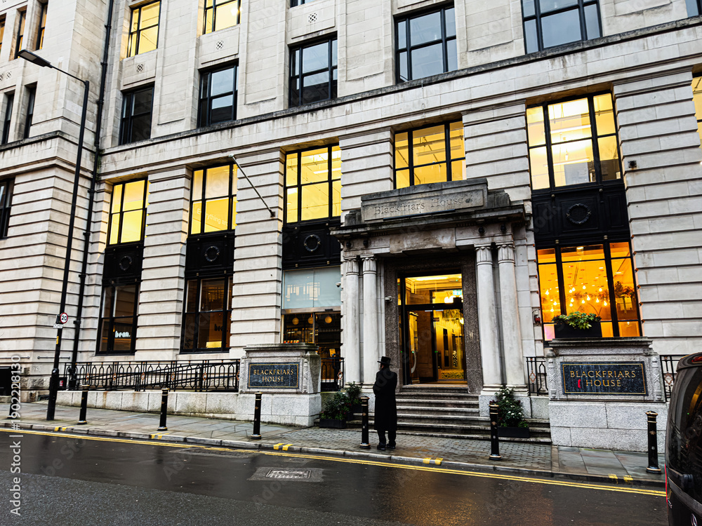 Obraz premium Manchester Blackfriars House building entrance with warm lights and stone columns on city street
