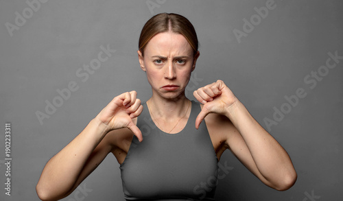 looking sad, disappointed or angry, showing thumbs down in disagreement, feeling frustrated. fitness concept