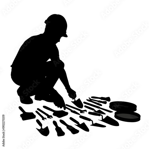 Silhouette of an archaeologist examining tools during an excavation project.