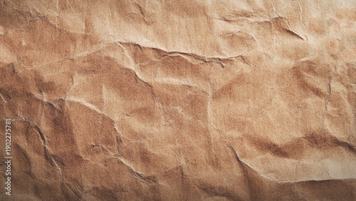 Brown crumpled kraft paper texture with deep folds and creases. 