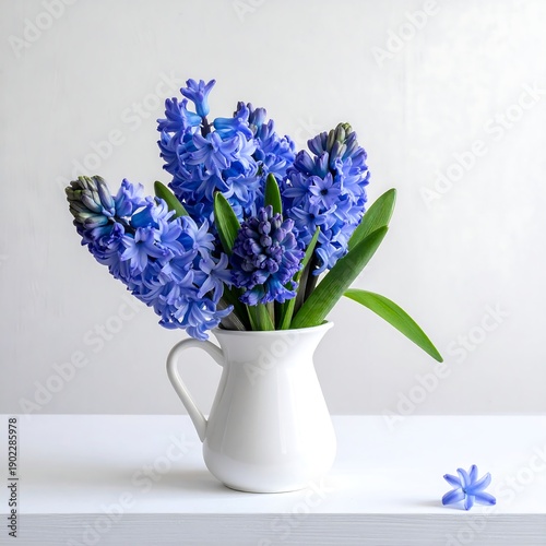 Vivid blue flowers burst from a small, white ceramic vase