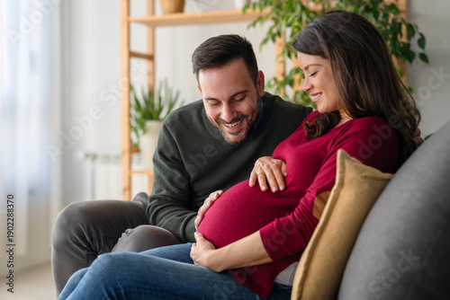 Fotografía Beautiful pregnant woman and her handsome husband are smiling while spending tim