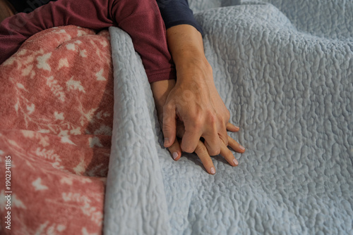 Couple holding hands in bed during morning routine