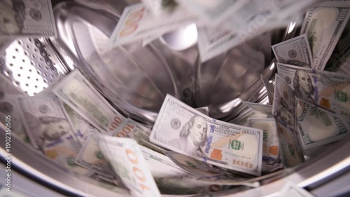 Hundred United States Dollar banknotes inside washing machine for money laundering and fraud concept.