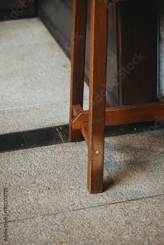 The legs of a scratched wooden chair outside of a store