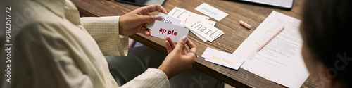 Fotografía Caucasian woman tutor holding flashcard with word apple, teaching young student